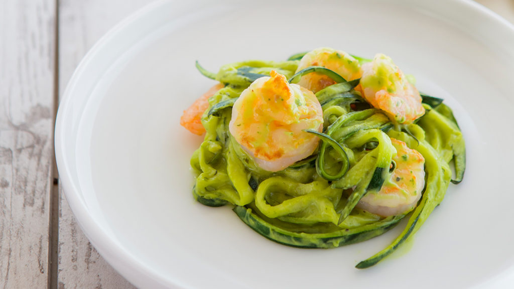 Avocado zucchini noodles with shrimp on white plate