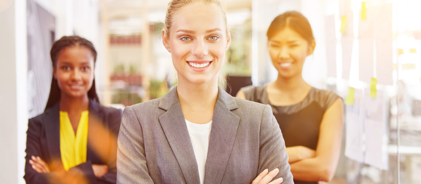 Three business women standing with arms crossed