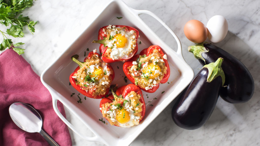 stuffed quinoa red peppers with eggs in white square casserole