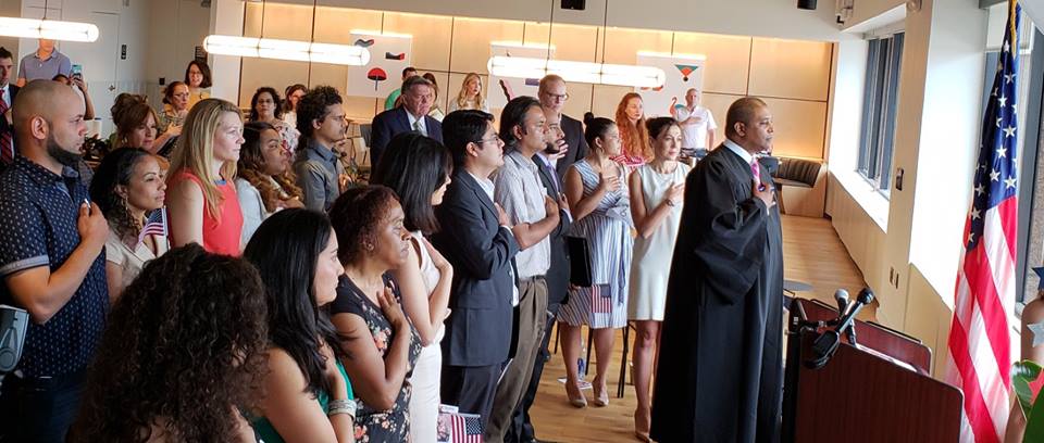 U.S. District Judge Donald Cabell leads the soon-to-be citizens in the Pledge of Allegiance