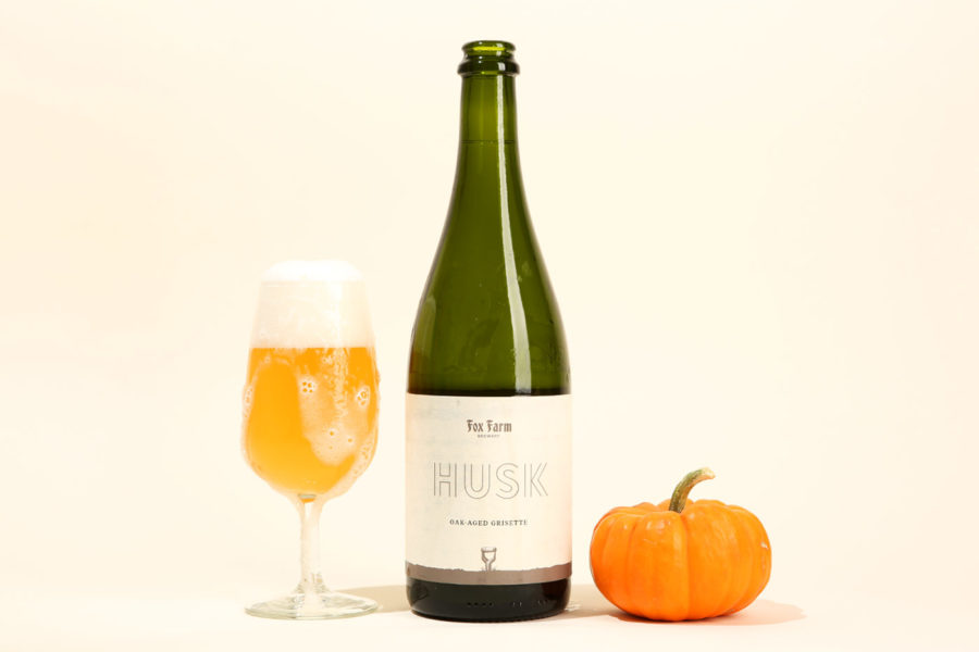Bottle and glass of Fox Farm Brewery Husk Grisette with mini pumpkin