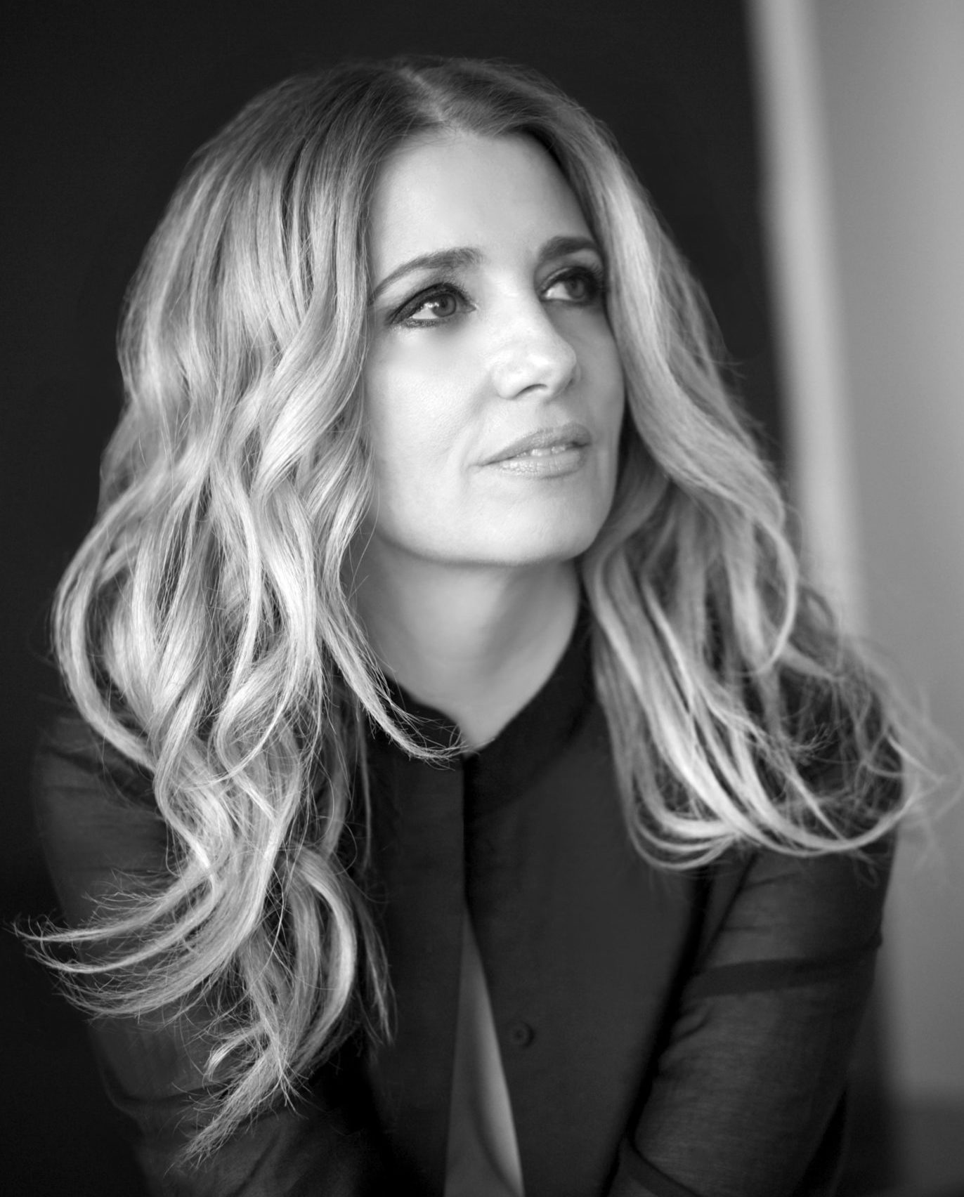 Black and white portrait of salon owner Patrice Vinci with long wavy blonde hair